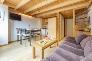 een woonkamer met een bank en een tafel bij Résidence Grand Roc - Campanules 403 - Happy Rentals in Chamonix-Mont-Blanc