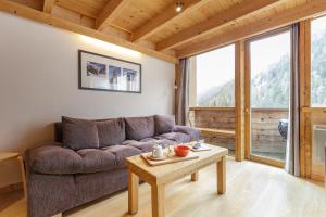 een woonkamer met een bank en een tafel bij Résidence Grand Roc - Campanules 403 - Happy Rentals in Chamonix-Mont-Blanc