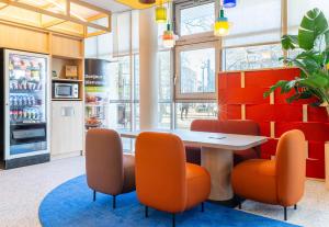 a restaurant with a table and orange chairs at B&B HOTEL Nantes Centre in Nantes