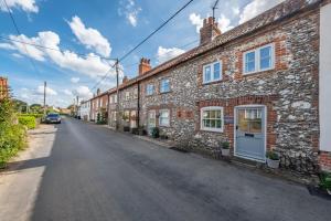 a row of brick houses on a street at Charnwood Cottage 4 in Burnham Market