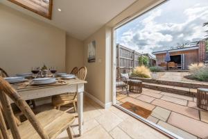 a dining room with a table and chairs and a patio at Charnwood Cottage 4 in Burnham Market