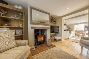 a living room with a couch and a fireplace at Charnwood Cottage 4 in Burnham Market