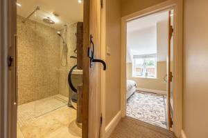 a bathroom with a shower and a glass door at Charnwood Cottage 4 in Burnham Market +28 photos