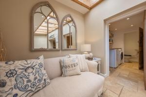a living room with a couch and a mirror at Charnwood Cottage 4 in Burnham Market