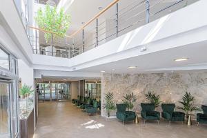 a lobby with green chairs and a staircase at Palangos Vetra in Palanga