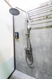 a shower with a shower head in a bathroom at Soleil Hostel in Ha Long