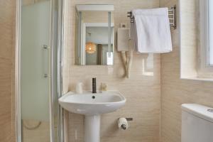 een badkamer met een wastafel, een spiegel en een douche bij Hipotel Paris Gare du Nord Merryl in Parijs