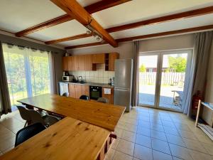 a kitchen with a wooden table and a refrigerator at Wigierska Osada in Danowskie
