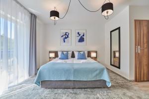 a bedroom with a large bed with blue pillows at Alcest Niechorze in Niechorze