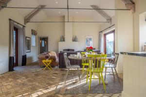 a dining room with yellow chairs and a table at Harnser Barn in Brisley