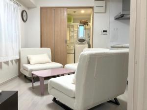 una habitación de hospital con 2 sillas y una mesa en The Emilio 102 Shinjuku newly renovated and opened in June 2024, en Tokio