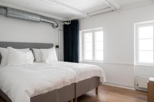 a bedroom with a large bed with white sheets at Kings Square apartments by Daniel&Jacob's in Copenhagen