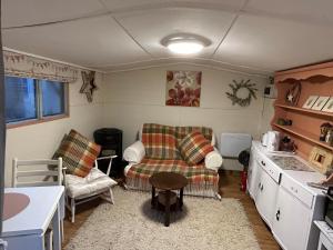 - une cuisine avec un canapé et des chaises dans la chambre dans l'établissement Cherryberry Lodges, à Abergavenny