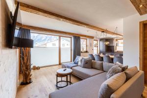 a living room with a couch and a table at Zugspitz Suites Lermoos by ALPS RESORTS in Lermoos