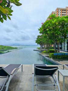 a pool of water with chairs and a table at Urban Suites - George Town, Penang in Jelutong
