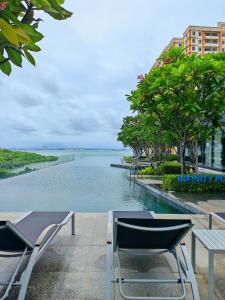 una piscina de agua con sillas y una mesa en Urban Suites - George Town, Penang, en Jelutong