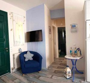 a living room with a blue chair and a table at Anastasia's apartment in Sami