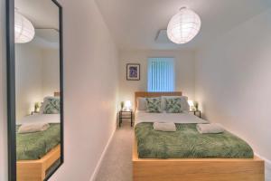 a bedroom with two beds and a mirror at Fantastic 2 Bedroom Apartment in Ashford in Ashford