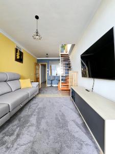uma sala de estar com um sofá e uma televisão de ecrã plano em Seaview Penthouse Magnificó Ático Duplex con vistas al mar em Manilva
