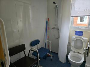 a small bathroom with a toilet and a chair at Castaways Holiday Park in Bacton +83 photos