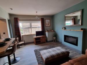 a living room with a couch and a fireplace at Trinket - The Cliff Top Cottage in Sewerby