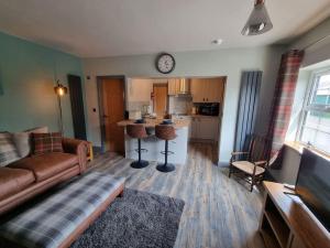 a living room with a couch and a kitchen at Trinket - The Cliff Top Cottage in Sewerby