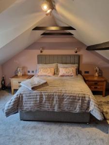 a bedroom with a large bed in a attic at Trinket - The Cliff Top Cottage in Sewerby