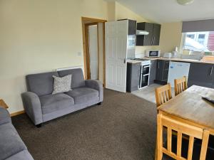 a living room with a couch and a kitchen at Castaways Holiday Park in Bacton