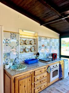 a kitchen with a counter with a sink and a stove at Il mare di Ognina in Siracusa