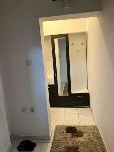 ein Badezimmer mit einem Spiegel und einem Teppich in der Unterkunft apartman centar S in Pirot
