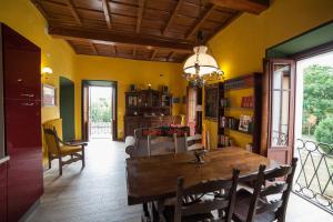 a dining room with a wooden table and yellow walls at All'Antico Convento in Cannero Riviera +26 photos