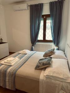 een slaapkamer met een bed met kussens en een raam bij Angy Relax Mare Aeroporto in Focene +28 foto's