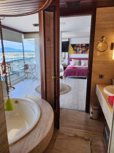 萊斯卡拉的住宿－Solo Atico Guest Suites，带浴缸的浴室和1间带1张床的卧室