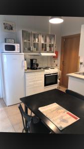 uma cozinha com uma mesa preta e electrodomésticos brancos em Guesthouse Langafit em Laugarbakki