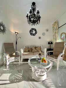 a living room with white furniture and a chandelier at SHR043 Nerja Medina Apartamento cerca de Playa Torrecilla in Nerja