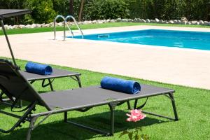 una mesa y una silla junto a la piscina en Villa Emerald en Asgourou