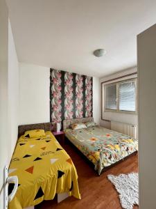 ein Schlafzimmer mit einem Bett mit gelber Decke in der Unterkunft apartman centar S in Pirot