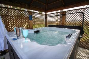 a jacuzzi tub with a wine glass in it at Hollicarrs - Forest Retreat in York
