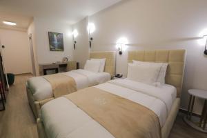 a hotel room with two beds and a table at Olia Residence in Tirana