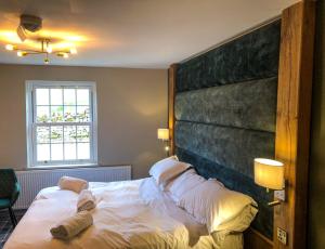 a bedroom with a bed with a large headboard at The Green Dragon at Hardraw in Hardraw