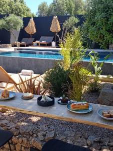 - un plateau de nourriture sur une table à côté de la piscine dans l'établissement Hôtel Les Suites Du Maquis, à Bonifacio
