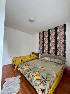 ein Schlafzimmer mit einem Bett mit einer bunten Bettdecke in der Unterkunft apartman centar S in Pirot