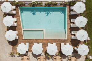 una vista aérea de una piscina con sombrillas blancas en Verano Afytos Hotel, en Afitos