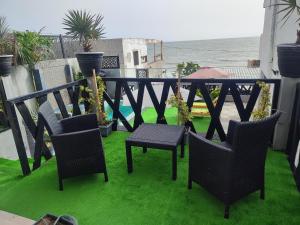 een balkon met stoelen en een tafel en gras bij La residence latinaya in Poponguine
