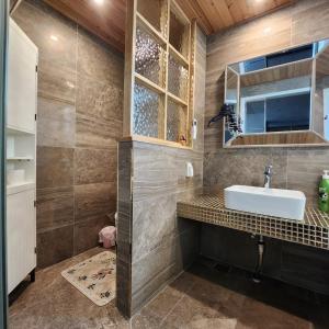 Ariene Guesthouse في غوانغجو: حمام مع حوض ومرآة