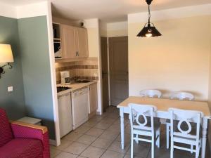 eine Küche mit Tisch und Stühlen in einem Zimmer in der Unterkunft Village Le Rouret - maeva Home - Appartement 2 Pièces 4 Personnes - Sélection MAE-5461 in Grospierres + 10 Fotos