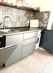 a kitchen with a sink and a washing machine at EcoCasa Neapolis in Siracusa