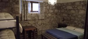 una camera con 2 letti e una finestra e un letto sidx sidx sidx di Villa Margarita a Capilla del Monte