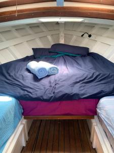 Una cama en un barco con dos toallas. en Lovely wooden boat in Port forum, with AC and two bikes. en Barcelona
