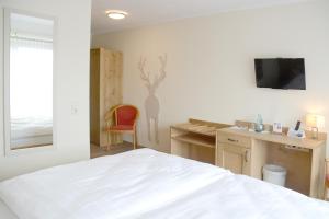 a bedroom with a bed and a desk with a chair at Bayrischer Hof in Melle